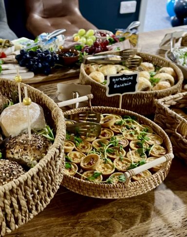 A selection of assorted appetisers presented in woven baskets on a wooden table.
